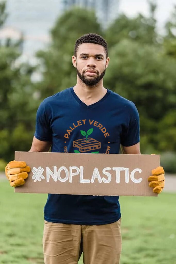 A guy wearing a Pallet Verde SHirt holding a sign no plastic